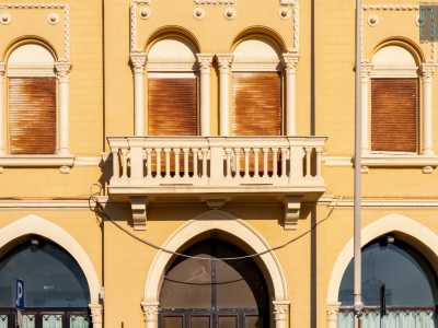 Il primo livello � invece contraddistinto da finestre ad arco (con sovrastanti decori a dentelli e a rosette), da un�elegante balconata centrale e da una merlatura sul parapetto